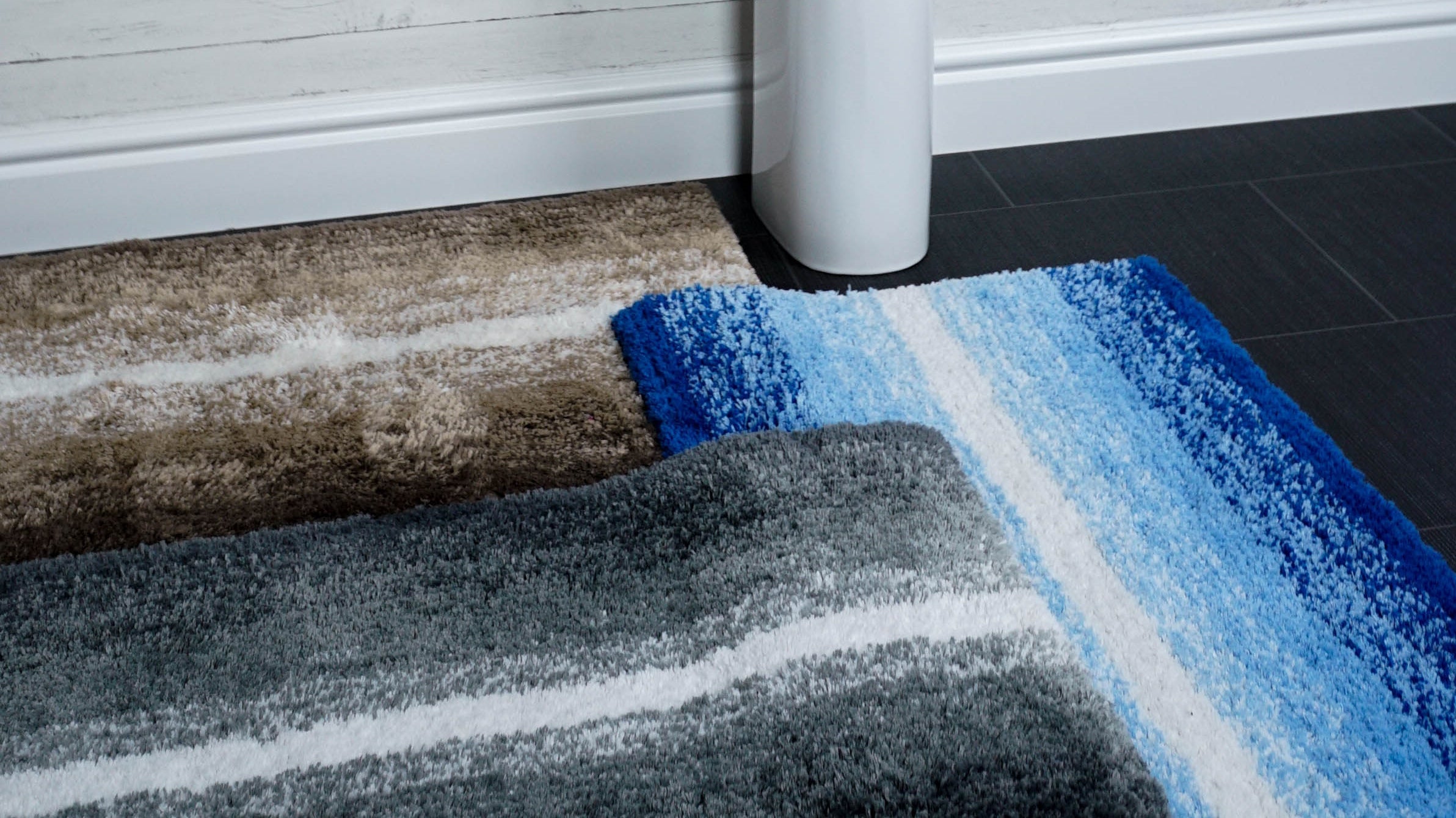colourful bath mats on display at base of sink pedestal