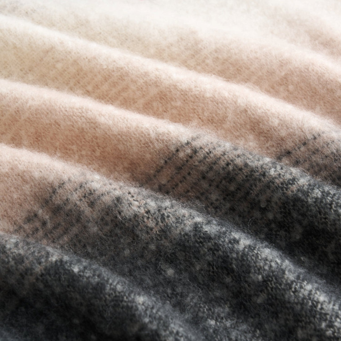 Close up of a faux mohair throw blanket in grey and cream.