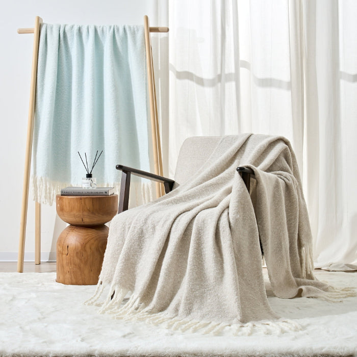 Faux mohair blankets with fringe tassels in blue or beige colours.
