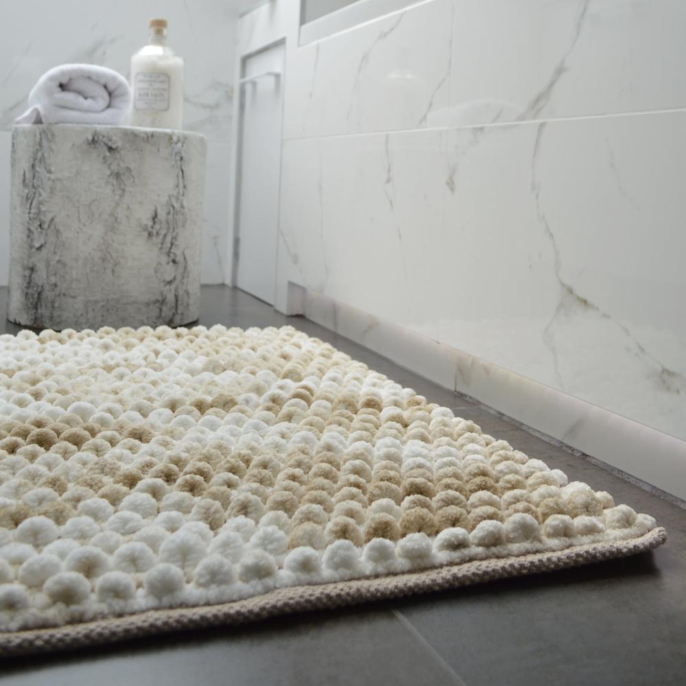 Thick beige bath mat, chunky bobble pile.