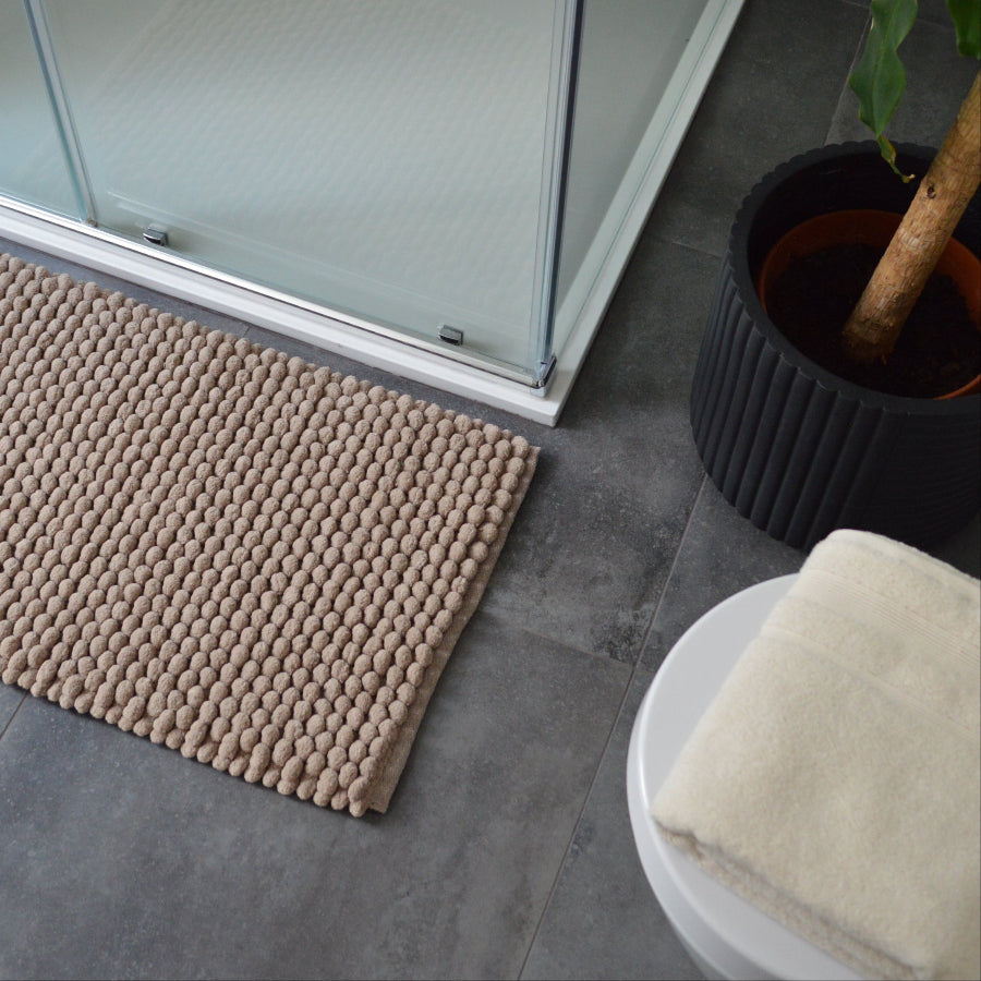 Plain brown bath mat with complimenting cream Egyptian cotton towels for great co-ordination in the bathroom.