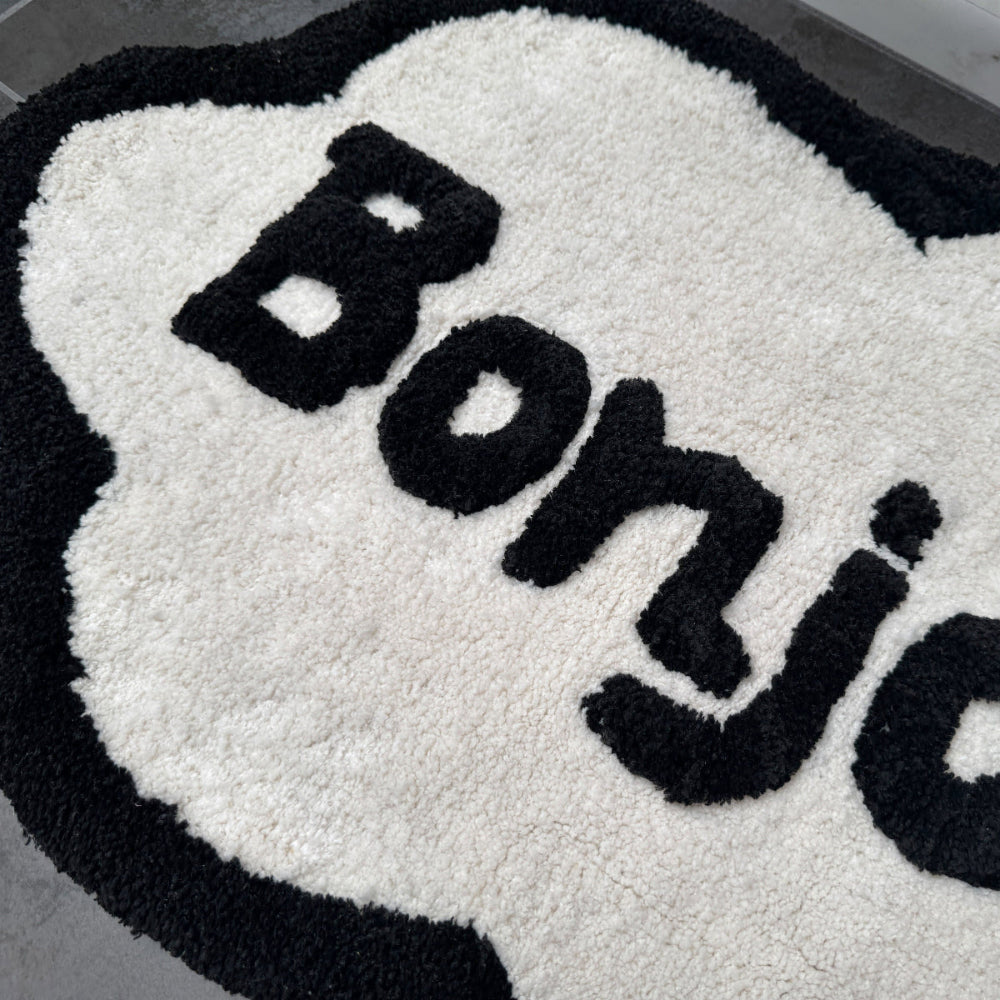 Hand tufted bath mat, with fun bonjour slogan.