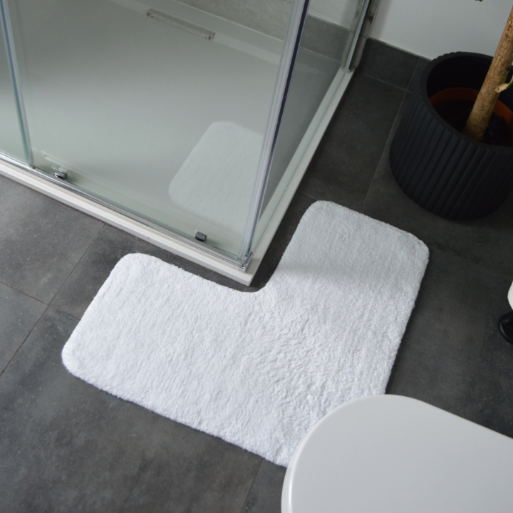 white corner shaped bath mat