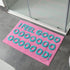 Pink bath mat with blue slogan design, I feel good.