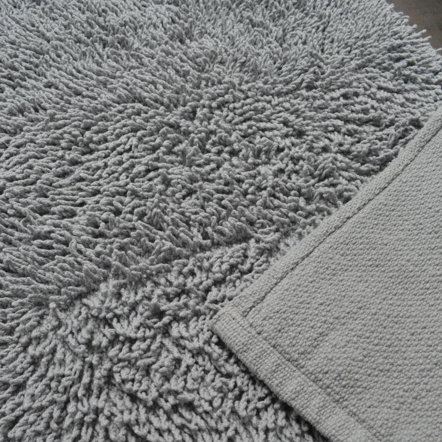 Light grey shaggy cotton bath mat.