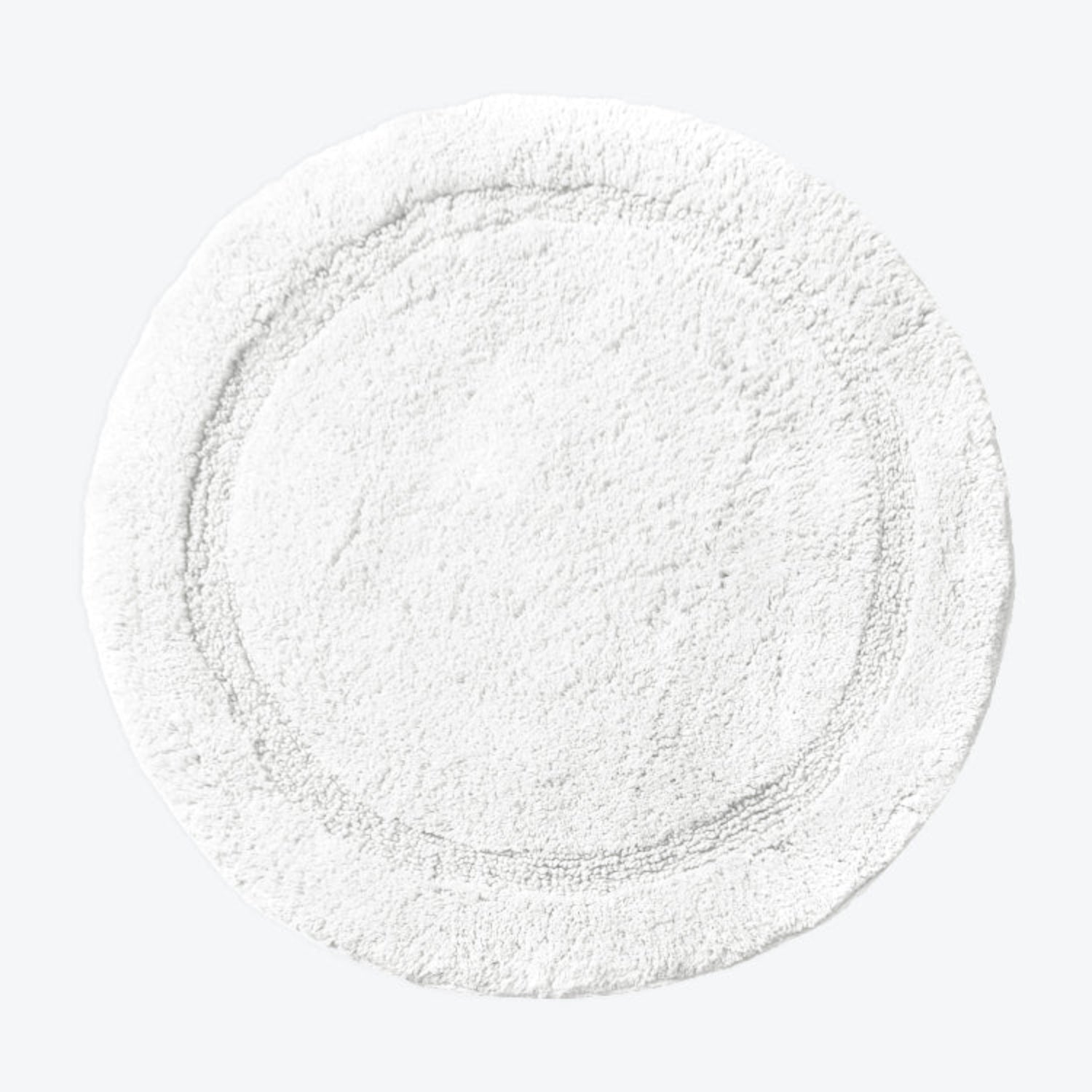 White cotton bath mat in round shape.