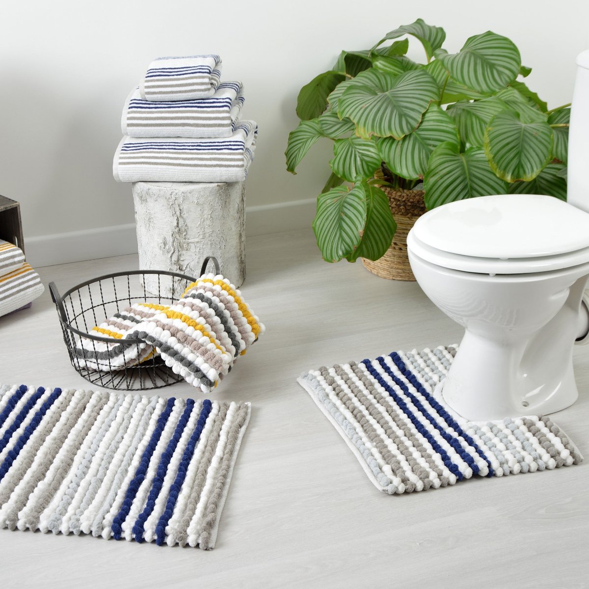 a chunky bobble pedestal toilet mat around the base of a toilet