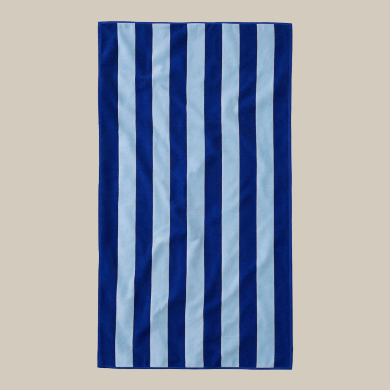 Striped beach towel with blue and light blue vertical stripes on a beige background