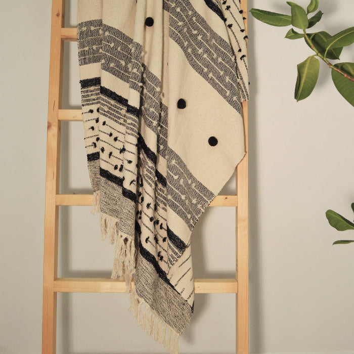Textured boho throw with pom poms, natural and black.