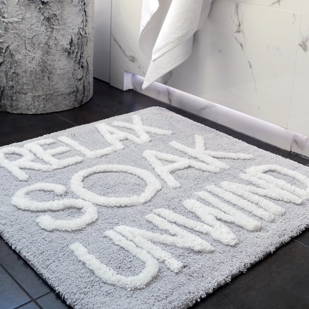 Hand tufted slogan bath mat, relax soak unwind.