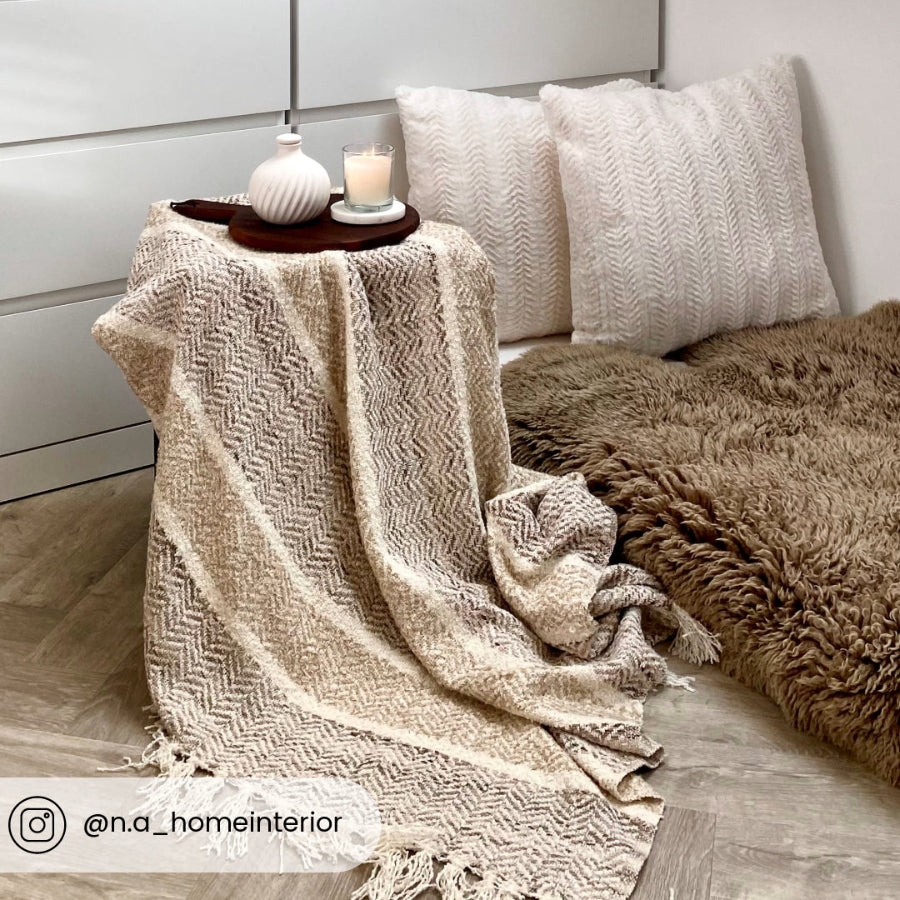 Neutral patterned throw in herringbone pattern.
