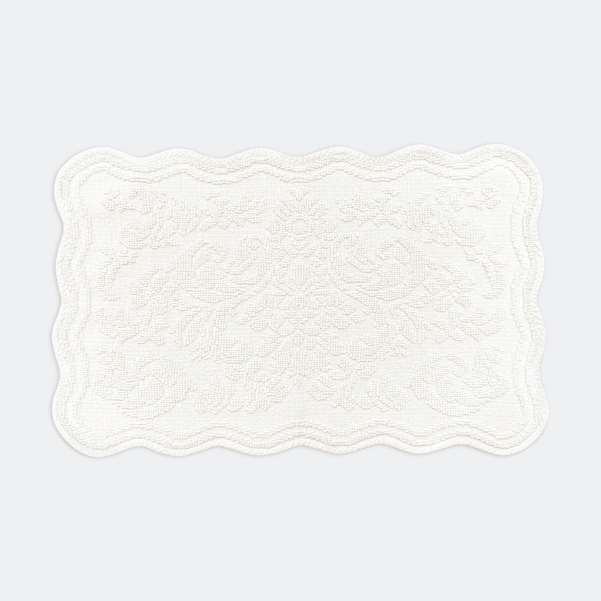 Scalloped bath mat in cream colour, with floral texture design - made from 100% cotton.