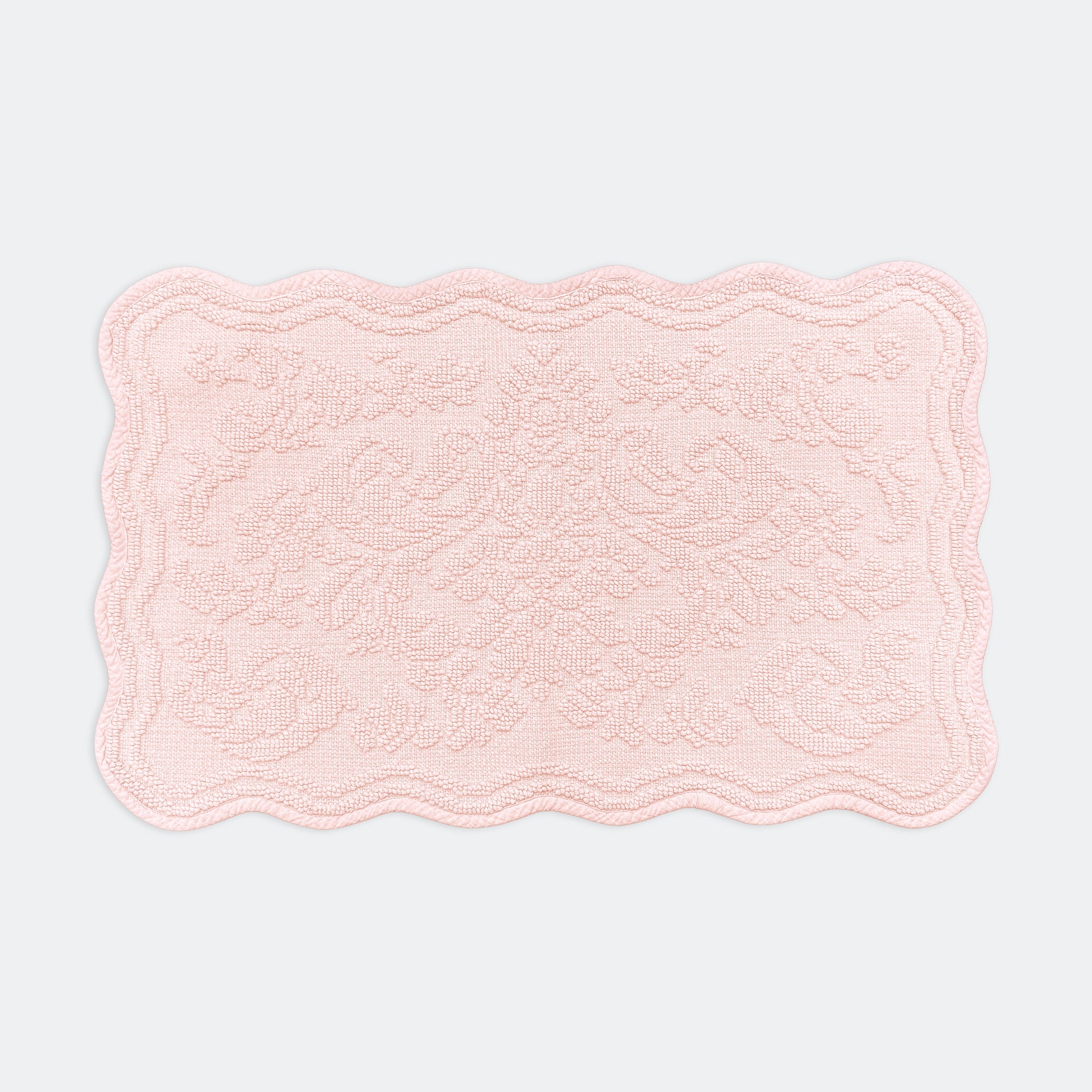 Scalloped bath mat in baby pink colour, with floral texture design - made from 100% cotton.