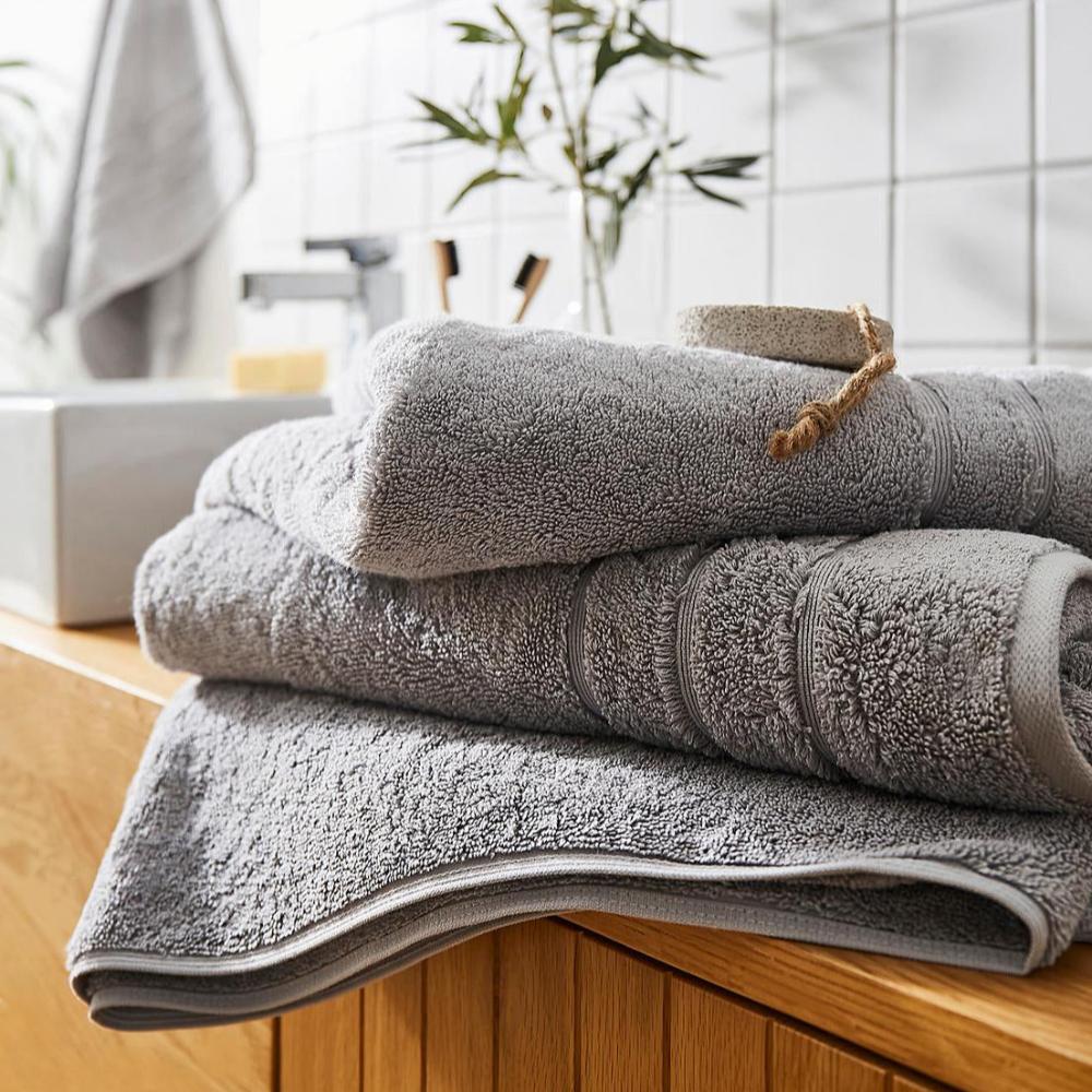 Light grey hotel towels made from thick and heavyweight cotton.