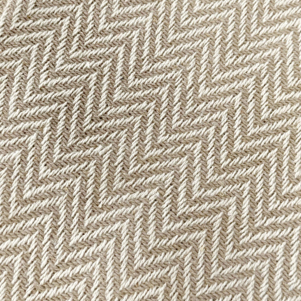 Beige and white patterned throw blanket, herringbone style.