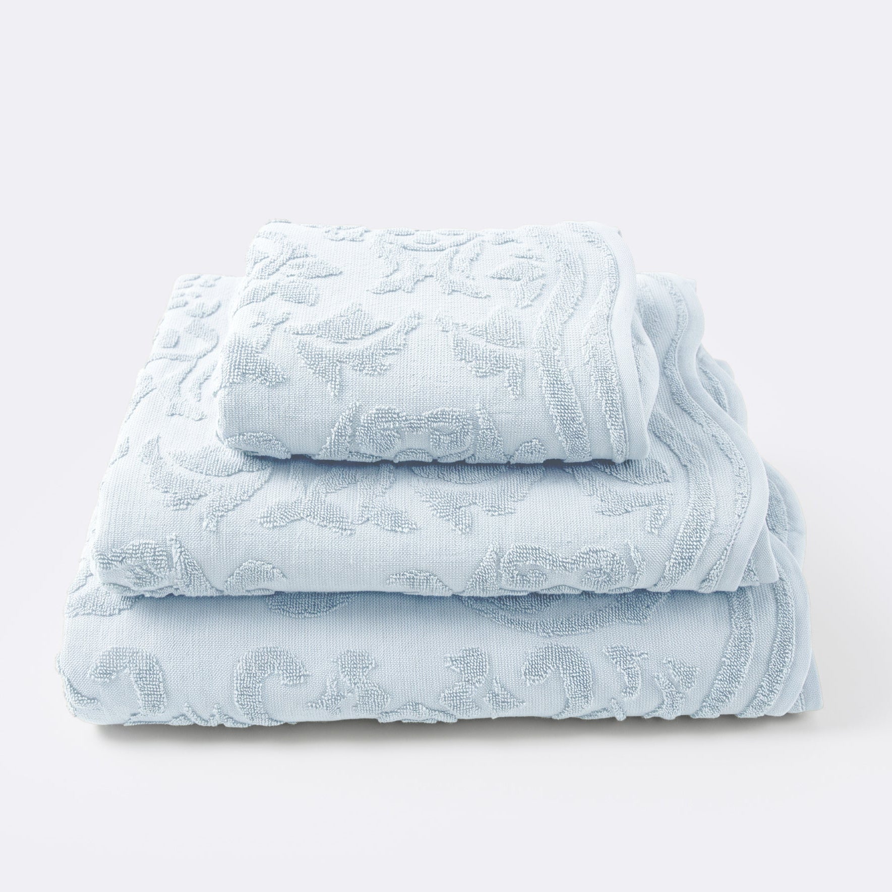 Set of towels for the bathroom with textured floral pattern - hand towel, bath towel and bath sheet in baby blue colour.