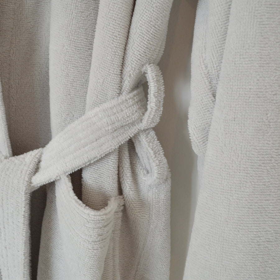 Close of a grey dressing gown with double belt loots for a perfect and comfortable fit.
