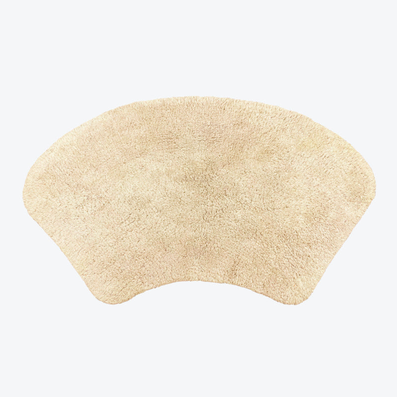 Beige curved bath mat for shower unit.