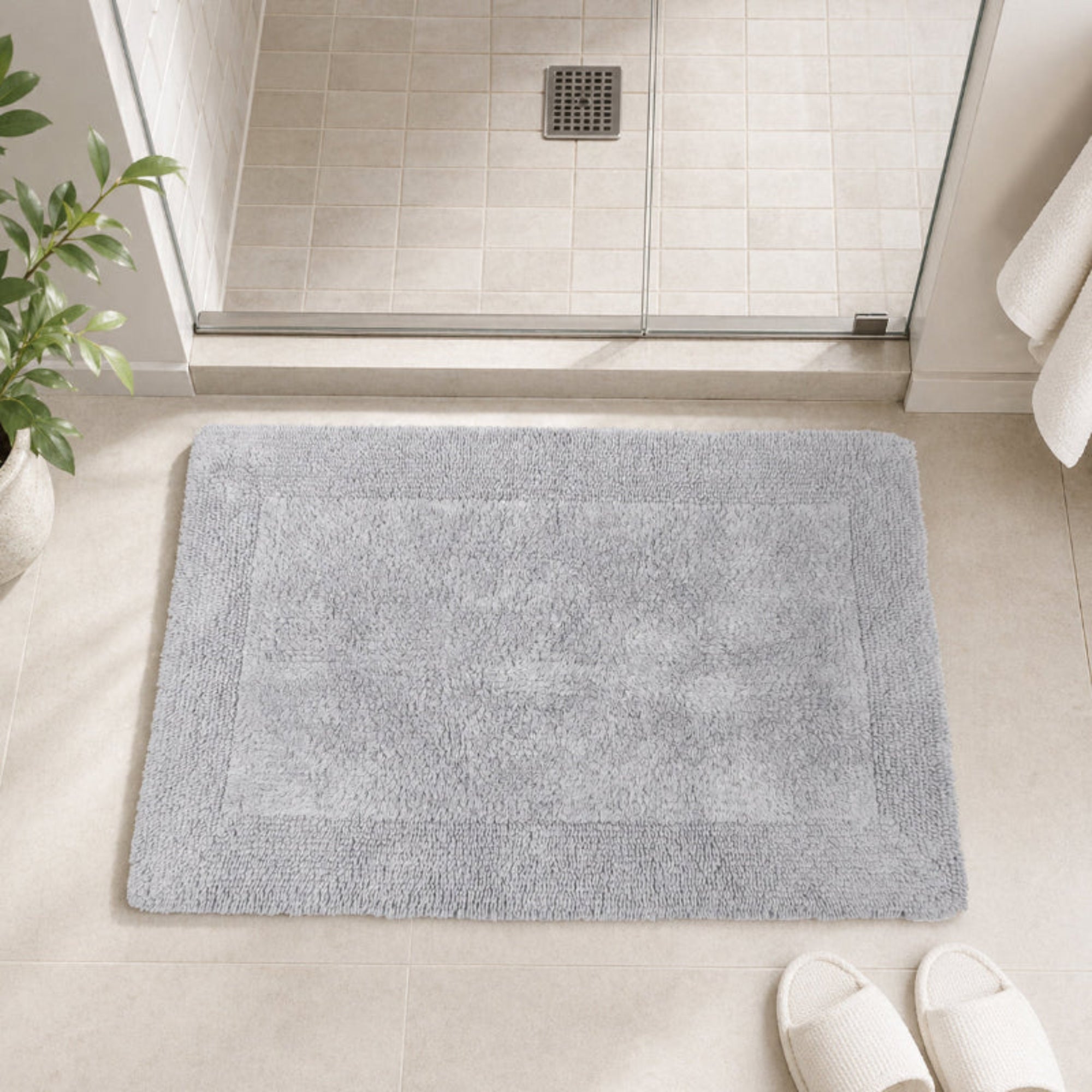 Grey reversible bath mat made from 100% cotton.