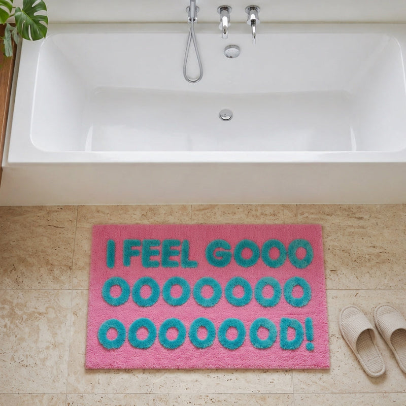 Fun bath mat in pink colour, with turquoise I feel good slogan.