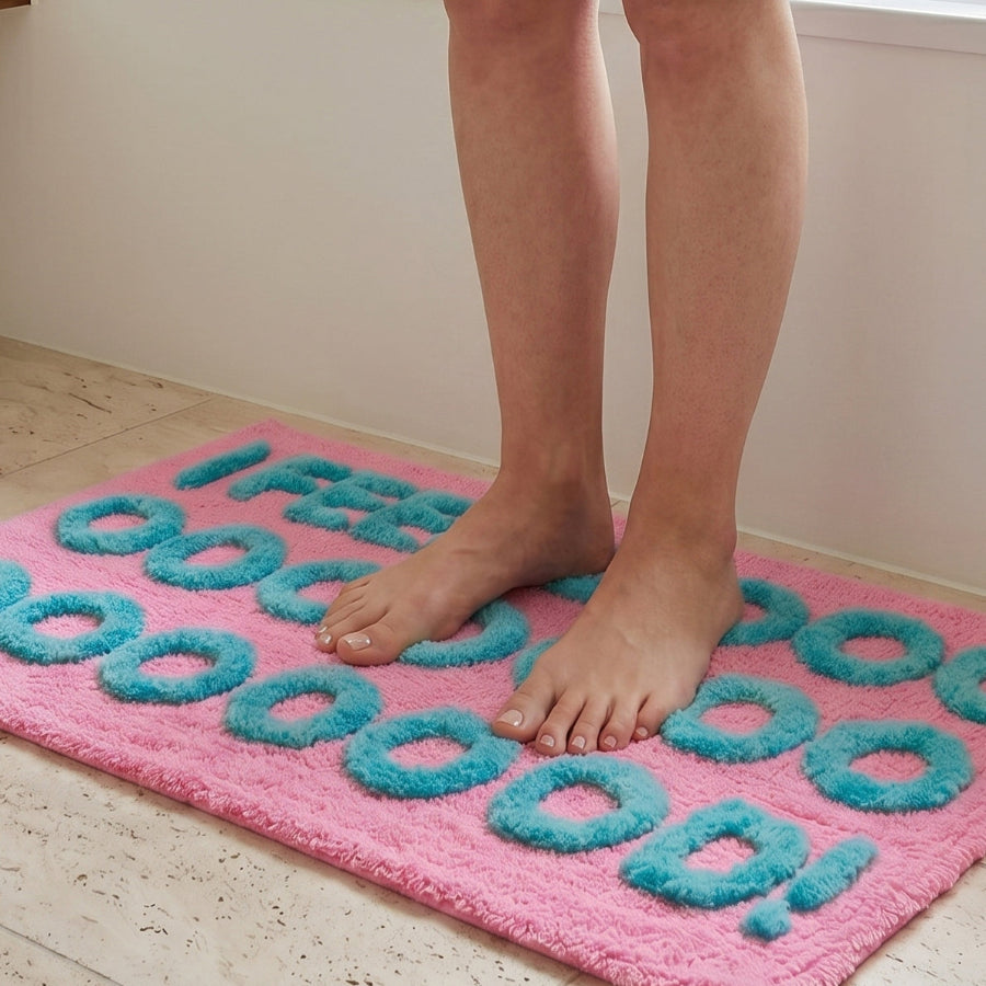 Close up of a hand tufted slogan bath mat in pink colour - I feel good.