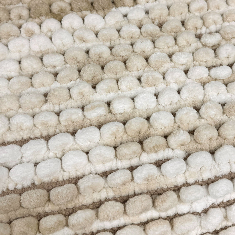 Beige bath mat in marble pattern.