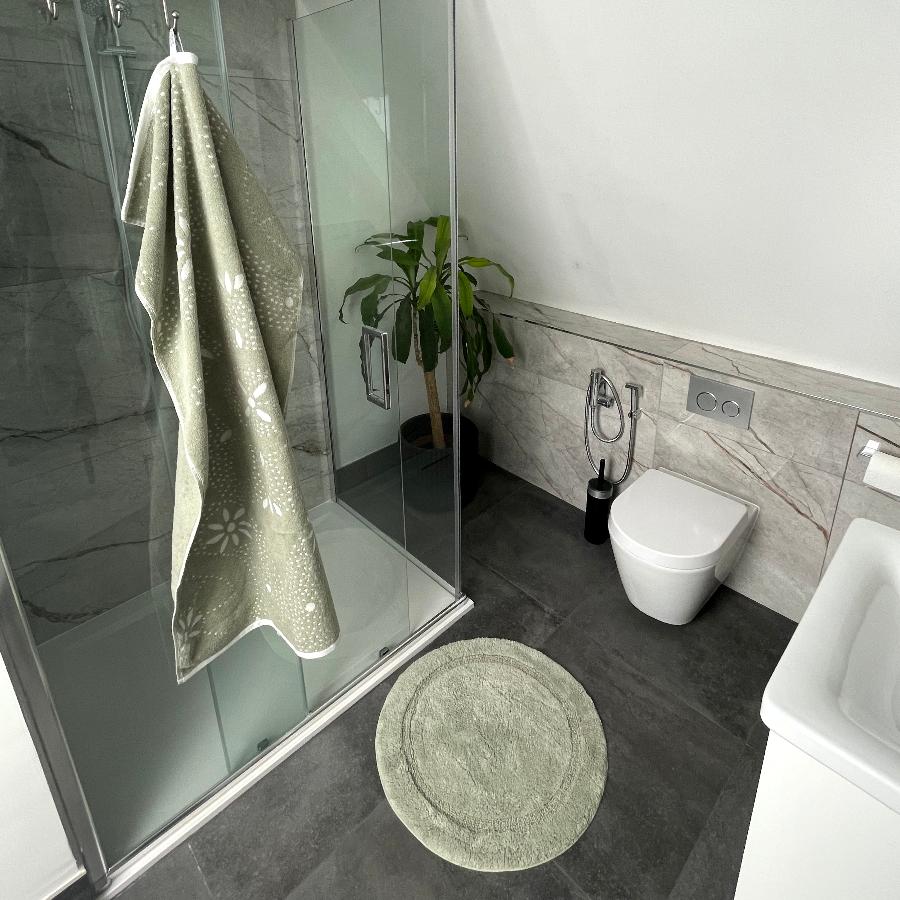 Sage green bathroom textiles. Matching round bath mat and towels.