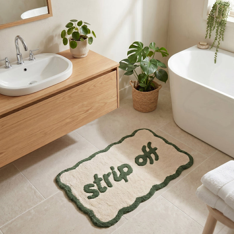 Green slogan bath mat in scallop shape - strip off design.
