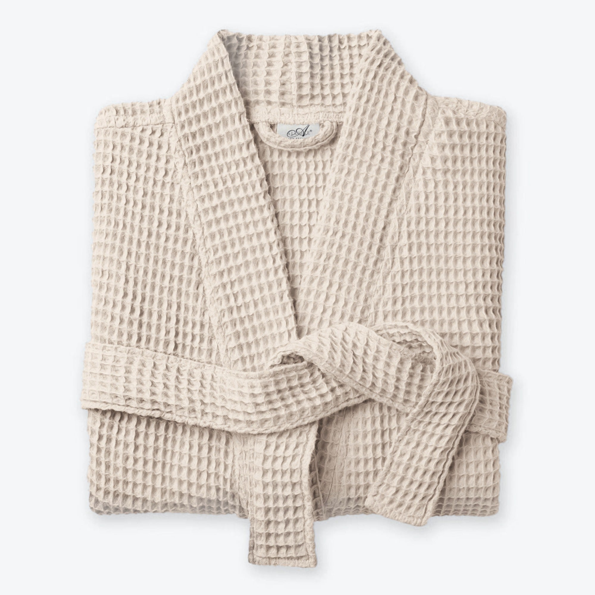 Beige neutral waffle bath robe with shawl collar, pockets and belt loop fastening.