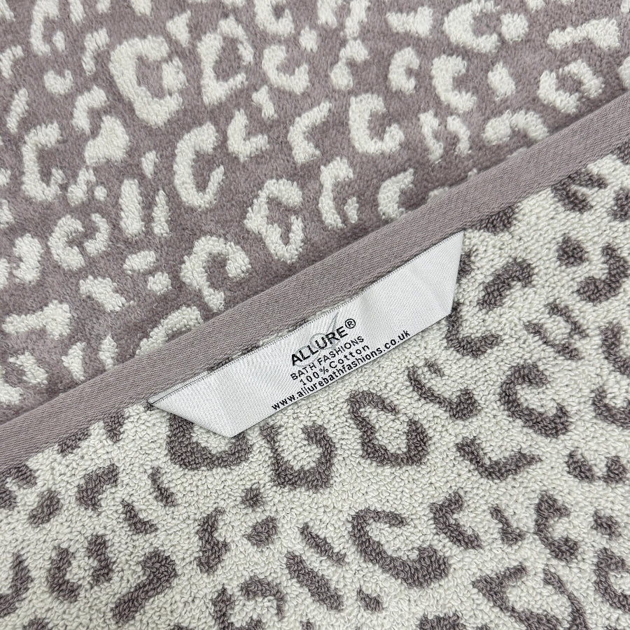 Grey and white patterned leopard towels with hanging loops for quick drying and easy storage.