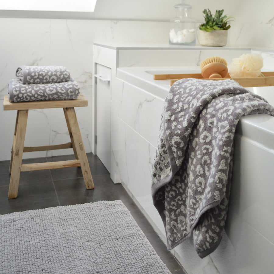 Grey and white bathroom towels in leopard print pattern.