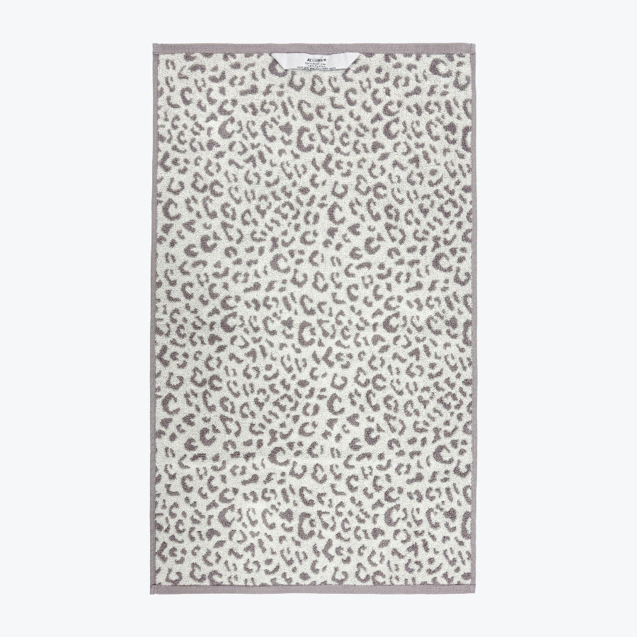 Grey and white leopard print towels with hanging loops.