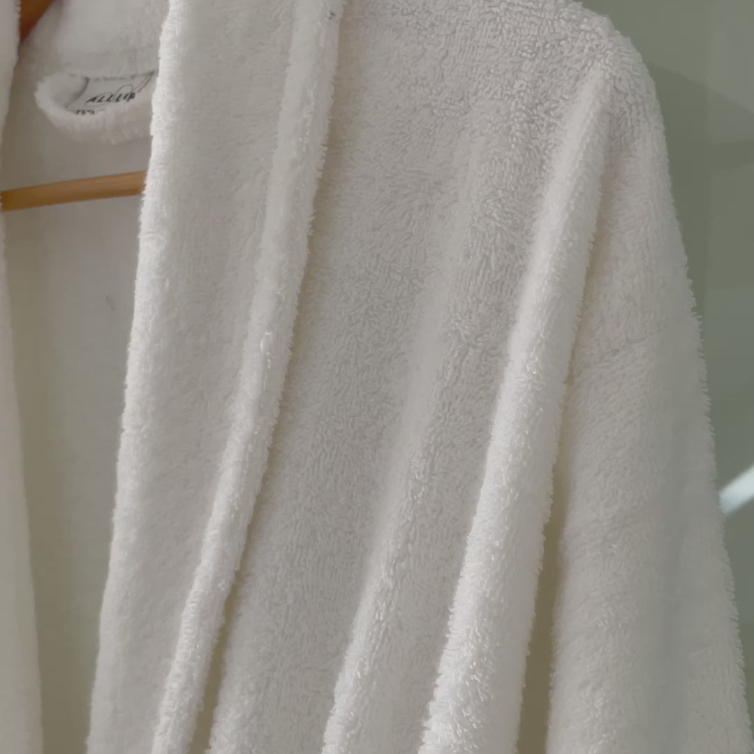 a video of a towelling bathrobe hung in a bathroom setting