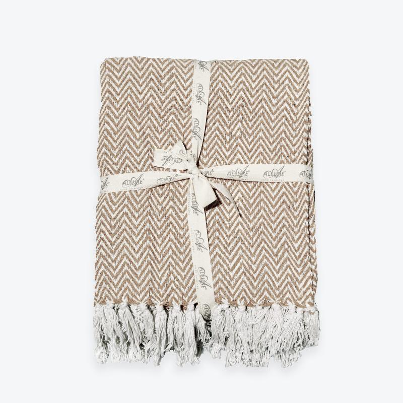 Beige chevron throw, stylish herringbone pattern.