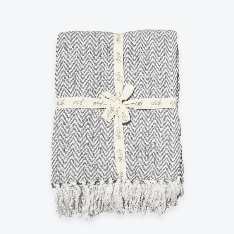 Light grey herringbone throw, ribbon tied blanket with chevron pattern and fringe..