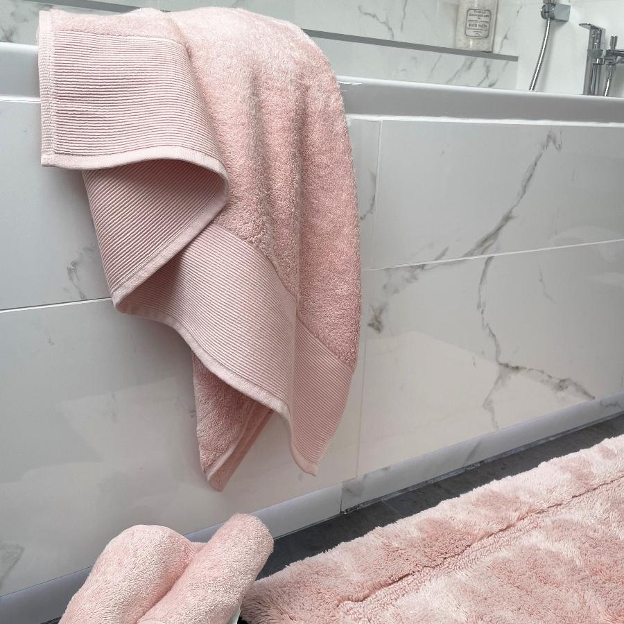 Blush pink bamboo bathroom decor. Bamboo sheets, face cloths, hand towels and bath towels.
