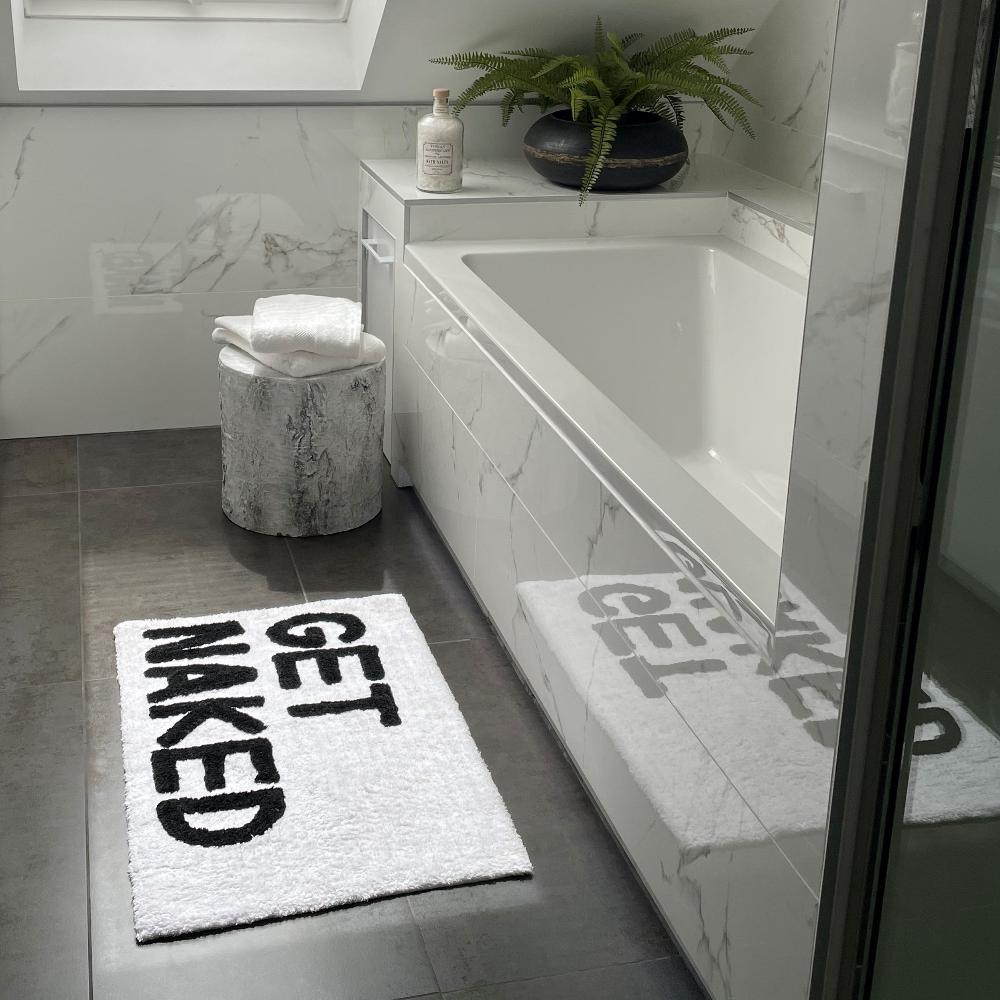 Bath mat with get naked slogan.