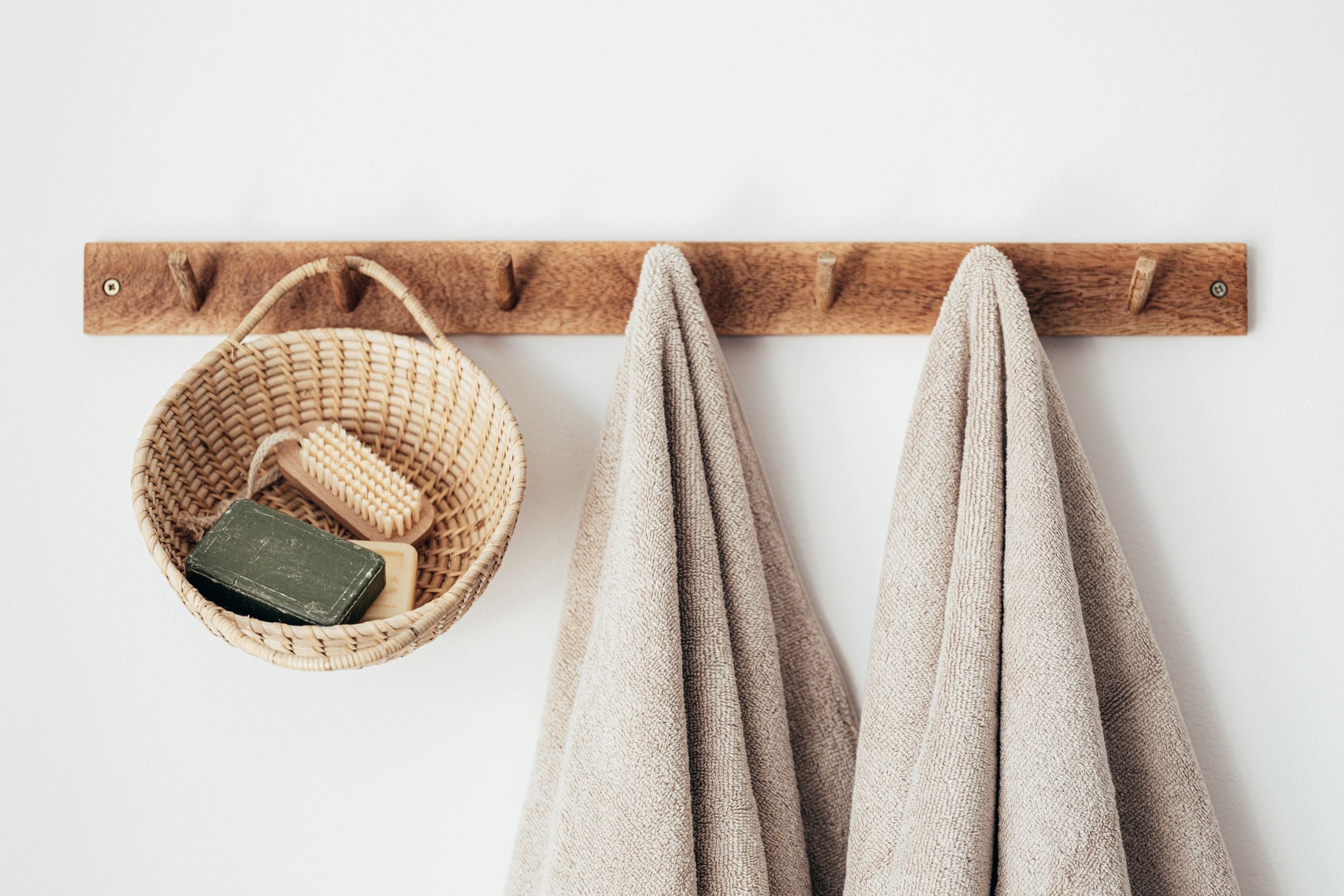 600 gsm towels hung on a wooden hook.
