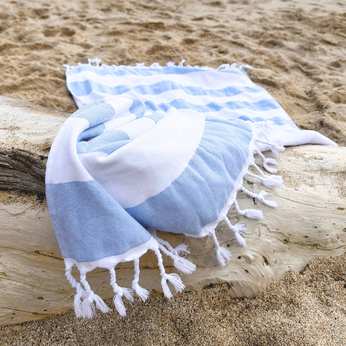 a white and blue hammam towel on a beach