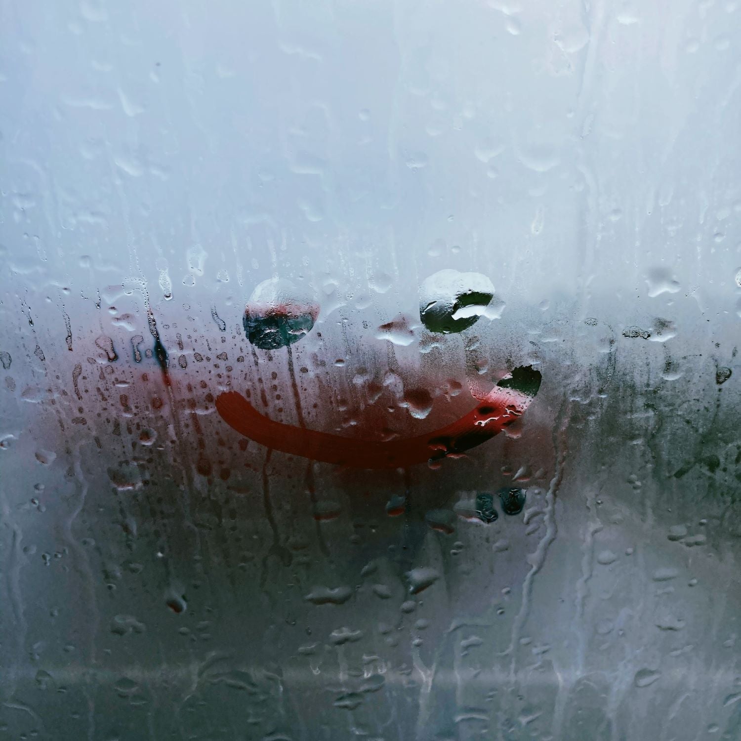 Steamy window with drawn smiling emoji