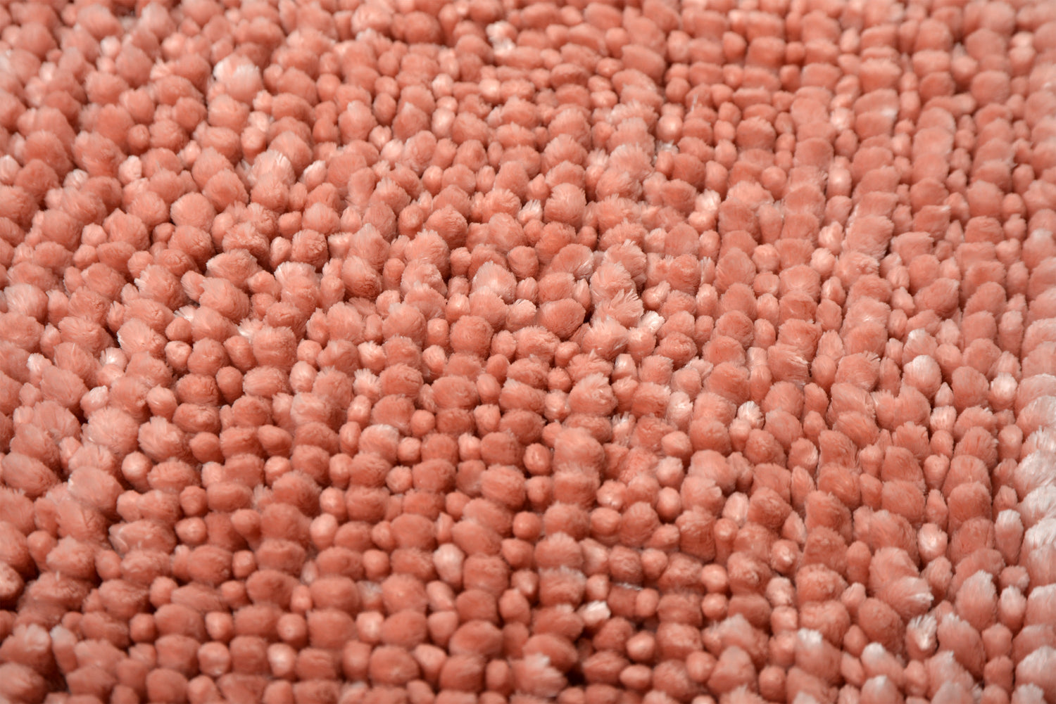 A close up of a bobble pink bath mat