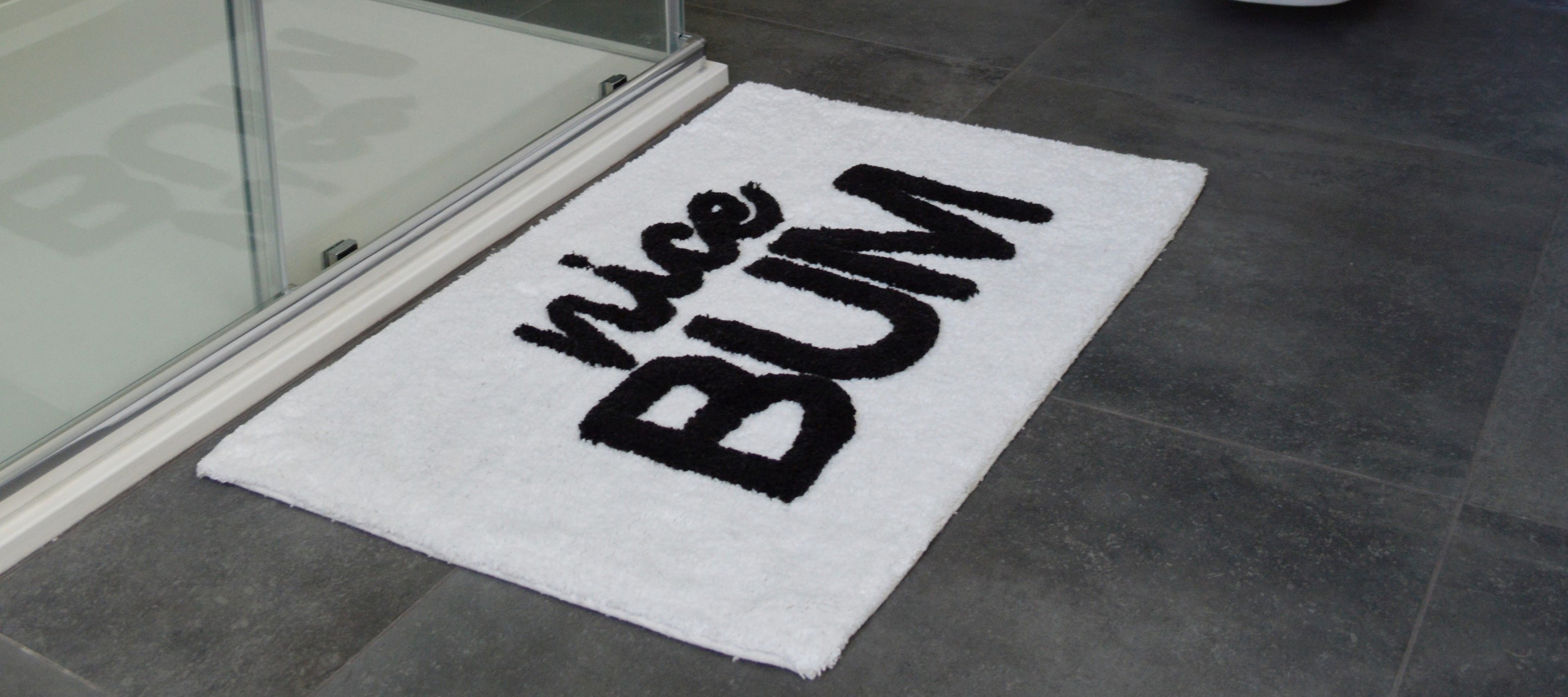 slogan bath mat with 'nice bum' text
