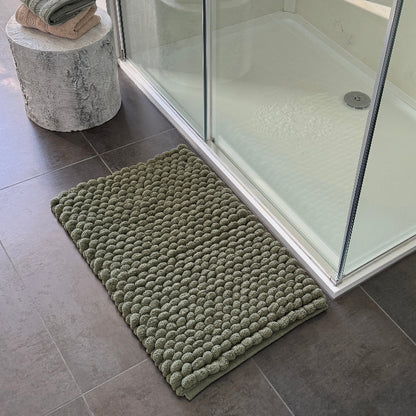 Dark green bathroom mats in a chunky bobble style for extreme comfort. 