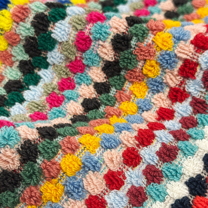 Rainbow colourful towels in fun striped pattern - close up of the popcorn bobble design.