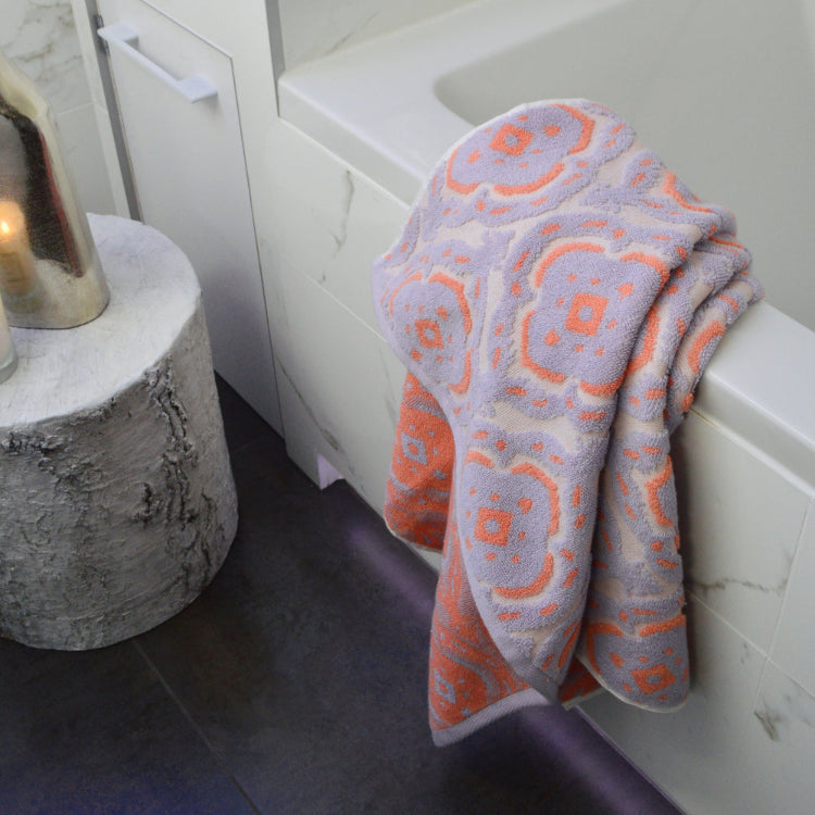 Patterned mandala towel in lilac and coral colours - textured jacquard design.