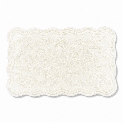 Scalloped bath mat in cream colour, with floral texture design - made from 100% cotton.