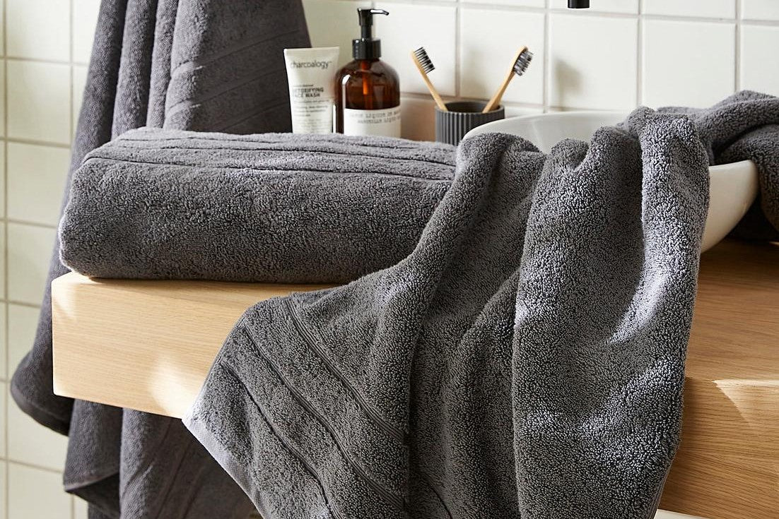 Charcoal grey bath towels in a bathroom.