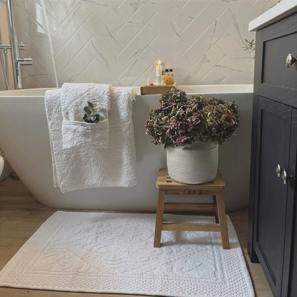 White country house towels and bath mat. Cotton jacquard bathroom accessories. 