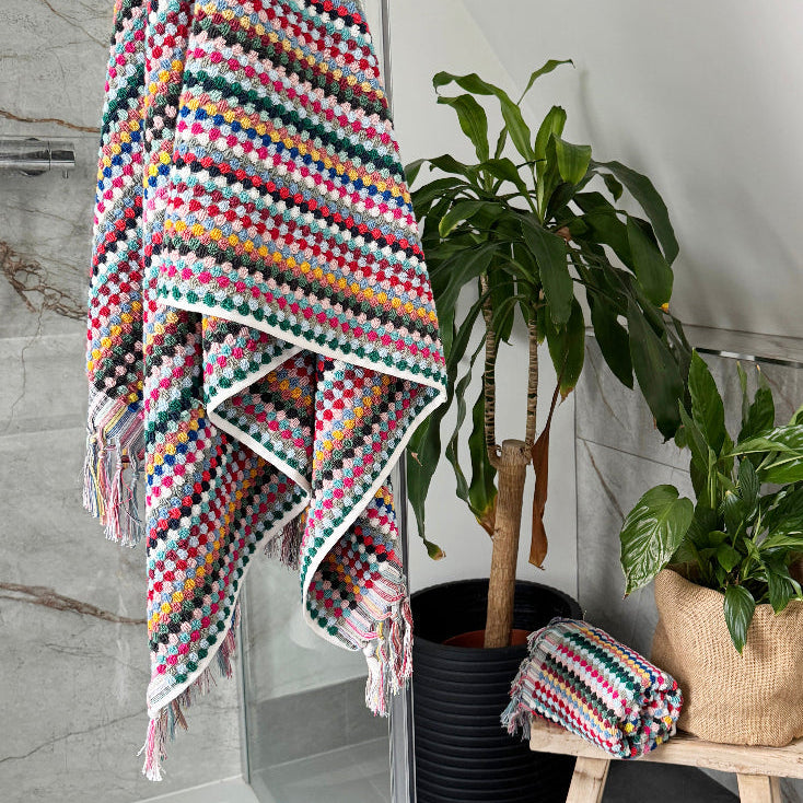 Colorful towels for the bathroom in fun pattern. Textured towels with fringe.