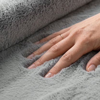 Hand touching a the pile of a softie rug in dove grey
